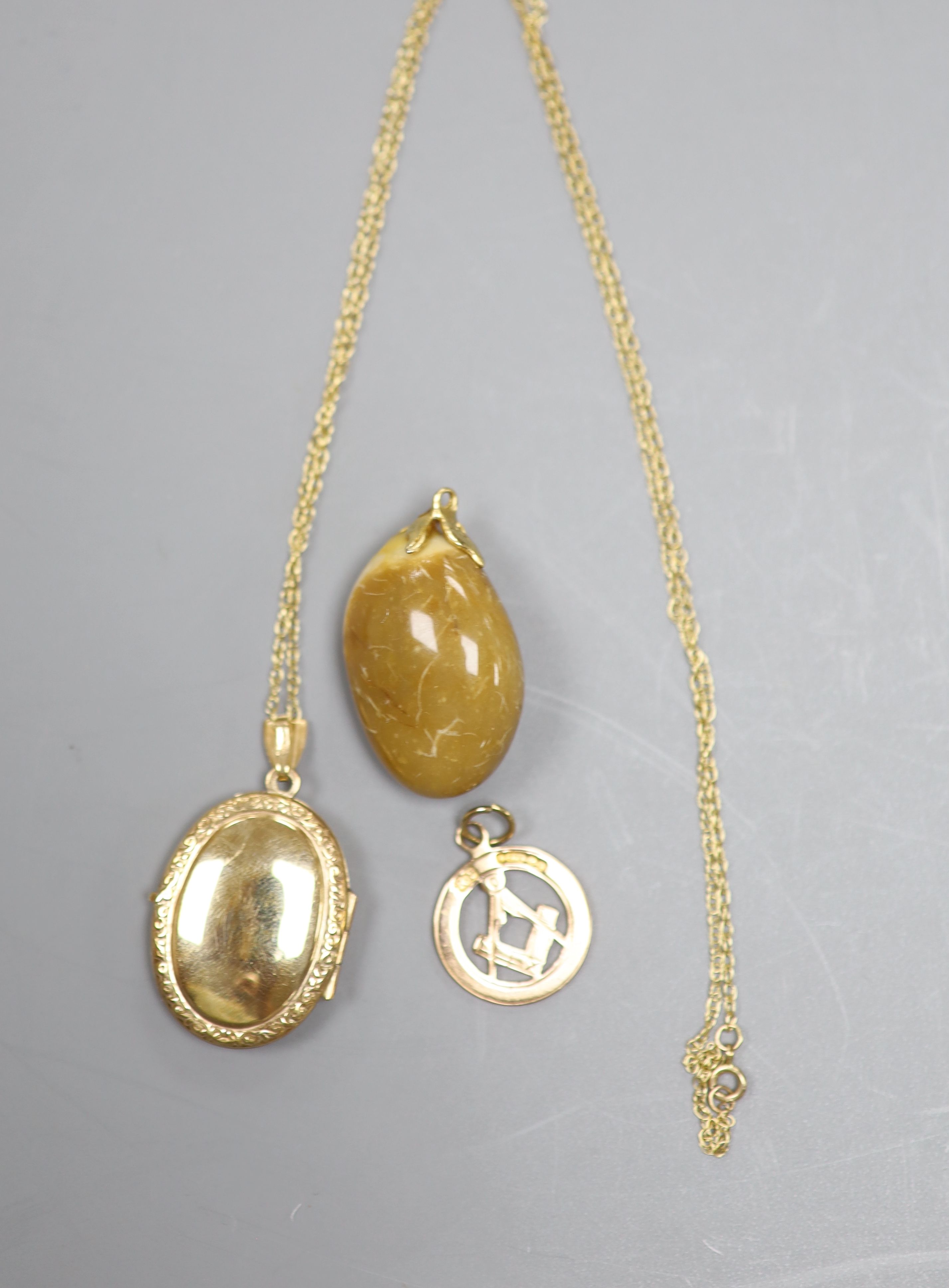 A 9ct gold Masonic watch fob, a 9ct gold locket and a hardstone pendant